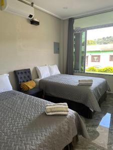 a hotel room with two beds and a window at Moderno & acogedor Apartmento, 2 habitaciones , 4 camas in Concepción de Ataco