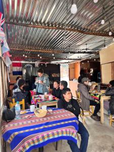 a group of people sitting at tables in a restaurant at Montañero Hostel in Huaraz