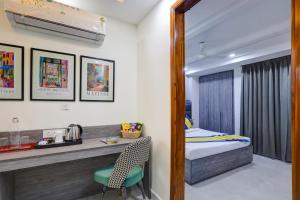 una camera da letto con un letto, una scrivania e una sedia di Liv Regalia - 1BHK Suites Near Huda CIty Centre a Gurgaon Altre 98 foto