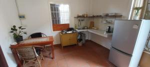een kleine keuken met een koelkast en een tafel bij Roza Guest House in Kampot