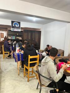 a group of people sitting at tables in a room at Montañero Hostel in Huaraz
