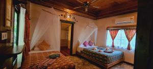a bedroom with two beds in a room with a window at Longtail Beach Resort in Thong Nai Pan Yai