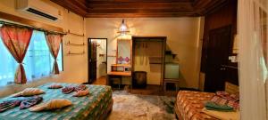 a bedroom with two beds and a mirror at Longtail Beach Resort in Thong Nai Pan Yai