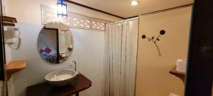 a bathroom with a sink and a mirror and a shower at Longtail Beach Resort in Thong Nai Pan Yai