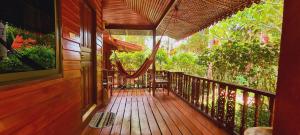 a porch of a house with a hammock on it at Longtail Beach Resort in Thong Nai Pan Yai