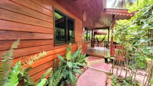 a wooden house with plants on the side of it at Longtail Beach Resort in Thong Nai Pan Yai