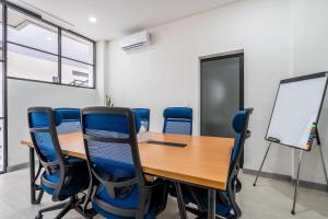a conference room with a wooden table and blue chairs at Standart Room in Sanur