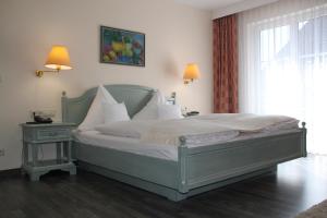 um quarto com uma cama, uma janela e uma mesa em Hotel Landhaus Waldesruh em Freudenstadt