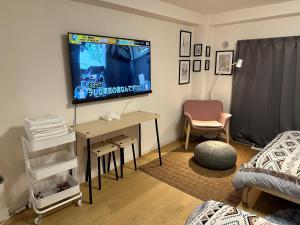 a living room with a tv and a desk with a table at 新宿神楽坂近く寿司店2 in Tokyo