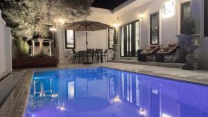 a swimming pool with an umbrella in a house at ChiLLTimeเวลาชิลล์ in Chiang Rai