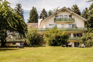 a large white house with a large yard at Hotel Landhaus Waldesruh in Freudenstadt