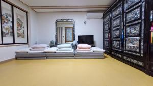 a living room with two couches and a mirror at Authentic Leedo Hanok in Seoul