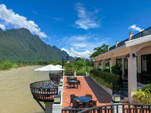 un resort con tavoli e sedie accanto a un fiume di Phalai view hotel a Vang Vieng