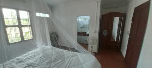 een slaapkamer met een bed met een sluier erop bij Roza Guest House in Kampot