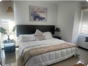 ein Schlafzimmer mit einem großen Bett in einem weißen Raum in der Unterkunft Modern Apartment Prime Location, Comfortable Apartment in Barranquilla