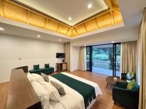 una camera da letto con un grande letto con due sedie verdi di Phalai view hotel a Vang Vieng