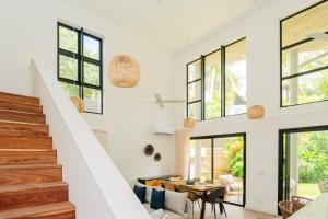 a home with white walls and windows and a staircase at The Luxe Retreat - Chic & Comfy in Grand Baie