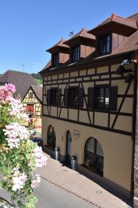 a large building with windows and flowers on a street at S'Harzala Taupe in Bergheim