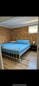 un grande letto in una stanza con un muro di mattoni di Sunshine Rooms a Maroochydore