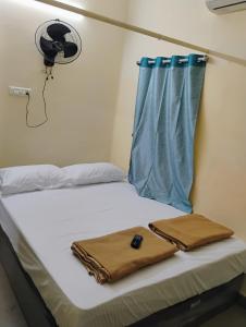 蒂鲁奇奇拉帕利Thiruveesar SVK Homestay的医院里的一张床位,配有袋子和风扇