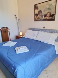 a blue bed with two towels on top of it at Una Terrazza su Como - Vista Panoramica in Brunate