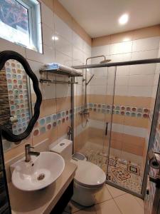 a bathroom with a sink and a shower and a toilet at Ambien's Place Residential Hotel in Dagupan +35 photos