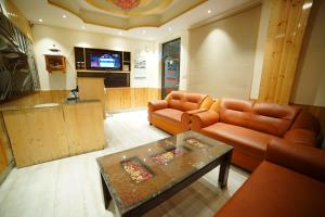 a living room with two leather couches and a table at The Royal Vista in Shimla