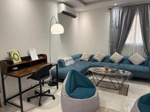 a living room with a blue couch and a table at Urban Bunks Hostel - سرير في غرفة مشتركة in Riyadh