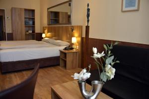 a hotel room with a bed and a table with flowers at Arthotel Munich in Munich