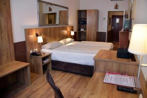 Schlafzimmer mit einem Bett, einem Schreibtisch und einem Spiegel in der Unterkunft Arthotel Munich in München