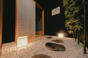 a room with three stones on the floor and a plant at 如意二条城Ruyi Nijojo in Kyoto