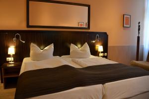 a hotel room with a large bed with white pillows at Arthotel Munich in Munich