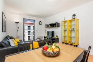 リスボンにあるArco da Graça Apartmentのリビングルーム(果物を入れたテーブル付)