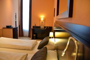 a hotel room with two beds and a desk at Arthotel Munich in Munich