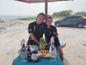 two men posing for a picture at a picnic table at Kilavethi Retreat in Hithadhoo
