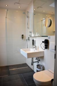 a bathroom with a sink and a shower and a toilet at Arthotel Munich in Munich