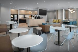 a restaurant with tables and chairs and a kitchen at TownePlace Suites by Marriott Fort Myers Gulf Coast in Fort Myers