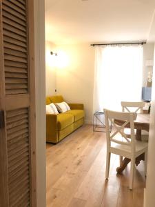 a living room with a yellow couch and a table at Les Petits Volets 3 appartements au choix in Antibes