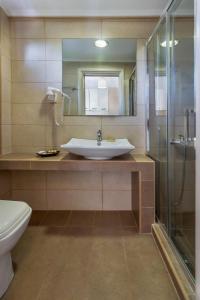 bagno con lavandino, doccia e servizi igienici di Evripidis Hotel ad Áfitos