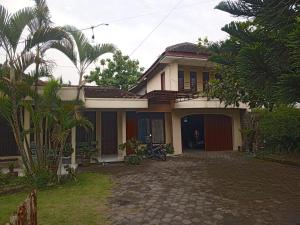 a house with a driveway in front of it at PW Homestay in Sleman