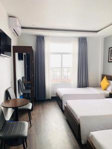 フエにあるHue Royal Hotelのベッド2台とテーブルがあるホテルの部屋 +92枚の写真