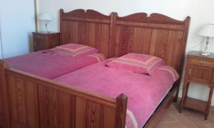 La VerdièreにあるDomaine Notre Dameのベッドルーム1室(ピンクのシーツが備わる大きな木製ベッド1台付)
