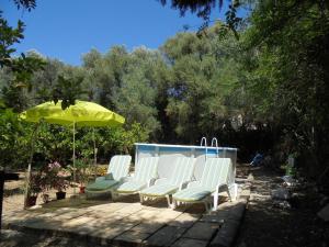 a group of white chairs and an umbrella at La Casita in Manacor