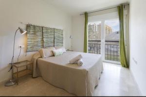 una camera da letto con un letto e una grande finestra di Coll Groc a Playa de Gandia