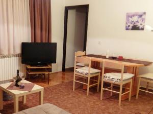 a living room with a table and a television at Apartment Rendulic in Rakovica