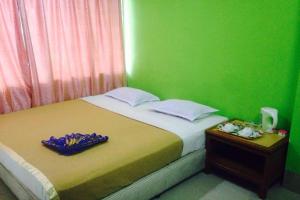 a bedroom with a bed with a green wall at F Hotel Bayan Lepas in Bayan Lepas