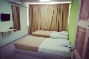 two beds in a small room with green walls at F Hotel Bayan Lepas in Bayan Lepas