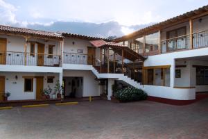 a building with balconies and stairs in a courtyard at Hotel Cacique Real in Zipaquirá