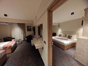 a hotel room with two beds and a desk at Zamzam Hotel 1 in An Najaf