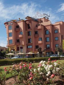 ein rosafarbenes Gebäude mit Blumen davor in der Unterkunft Amani Hotel Suites & Spa in Marrakesch